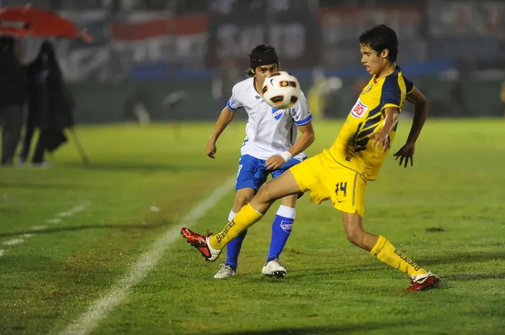 Disputando un balón con un jugador de América de México