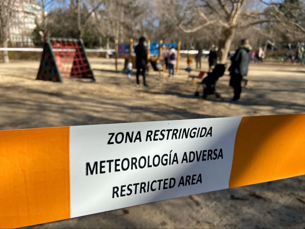 Un parque infantil restringido al paso con una cinta tras activarse la alerta naranja por meteorología adversa, en el parque de El Retiro.