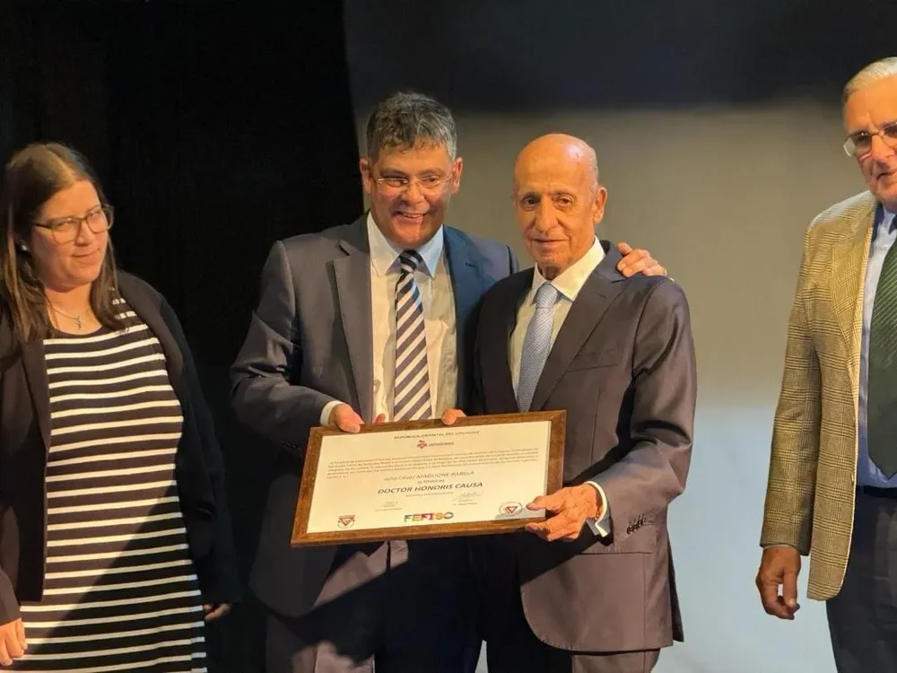 Julio César Maglione recibe su distinción Doctor Honoris Causa de manos de Lionel de Melo, decano del IUACJ