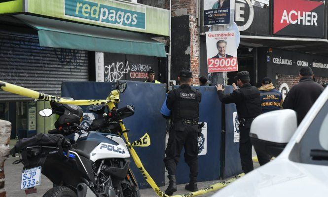Trabajo de la Policía en la escena del crimen, afuera del local de Redpagos de la Curva de Maroñas