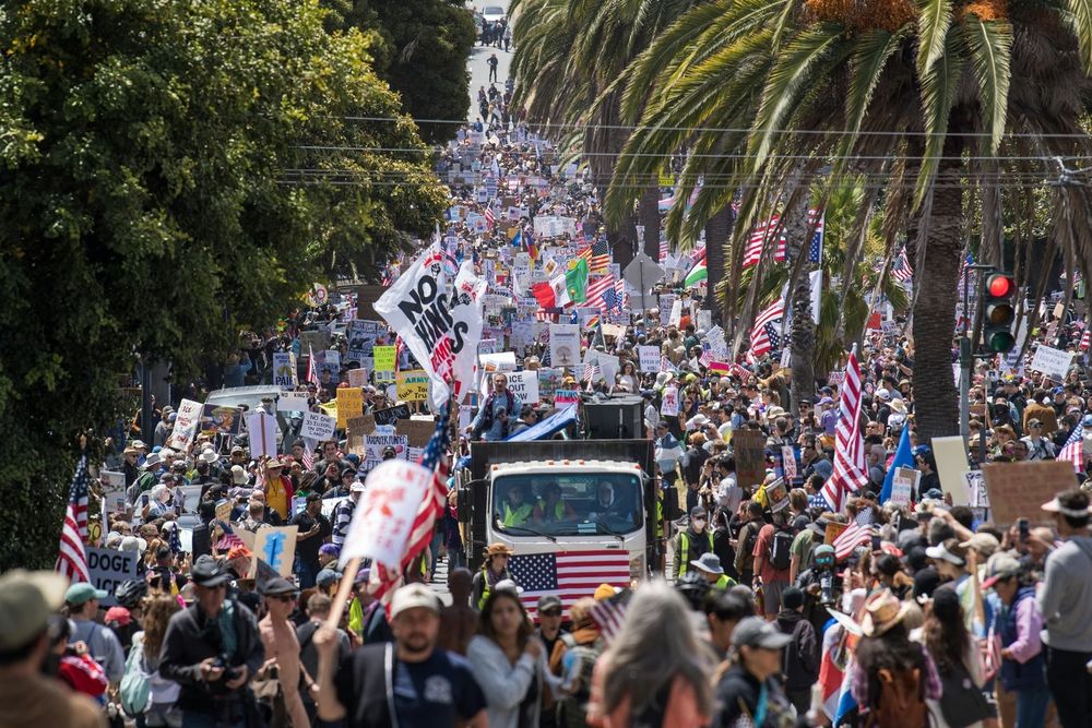 Los manifestantes sostienen carteles mientras marchan por la calle Dolores en protesta contra la administración Trump durante la manifestación No Kings en San Francisco el 14 de junio de 2025.