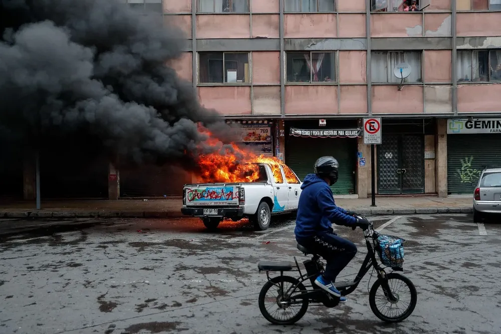 Un auto de la municipalidad prendido fuego tras encuentros entre la policía y los manifestantes en Santiago de Chile, por el 20220911 - Protestas en Chile durante el 49º aniversario del golpe de Estado