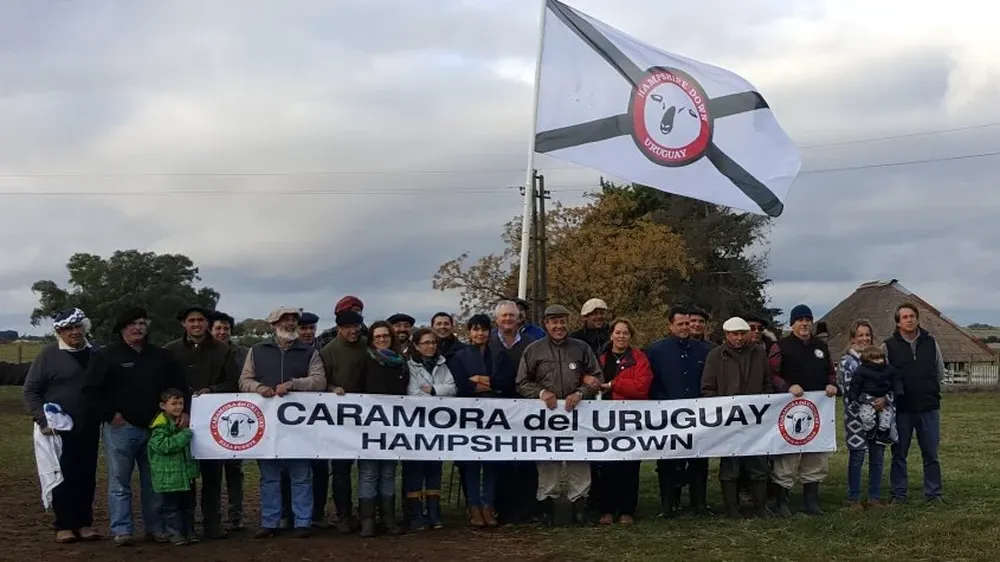 Los participantes de la Gira Hampshire Down con la bandera de la raza
