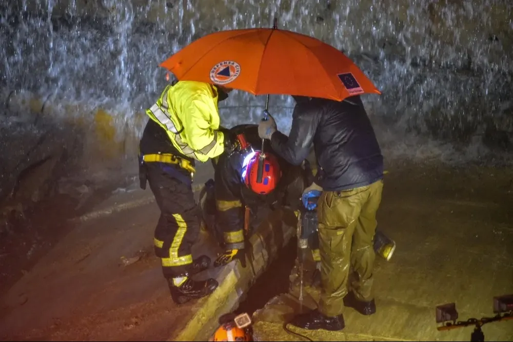 Rescatistas socorren a uno de los afectados por las inundaciones provocadas por las intensas lluvias.