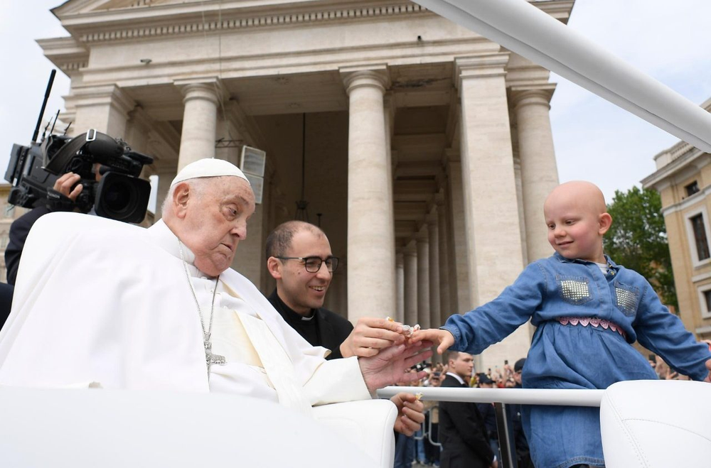 El papa Francisco en su último recorrido por la Plaza San Pedro, saluda a una niña enferma junto a su enfermero