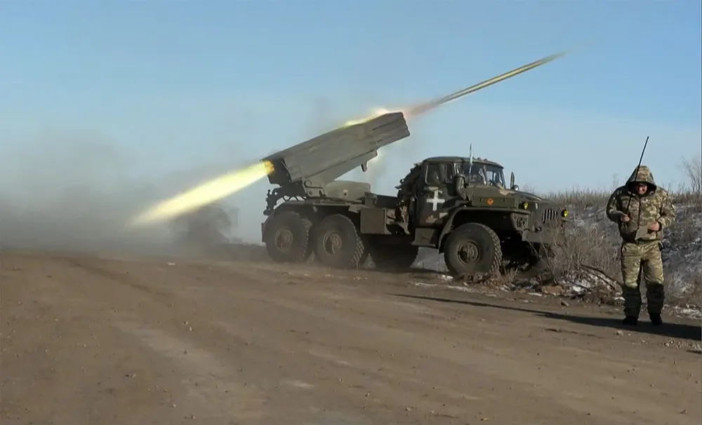 Un miembro del ejército de Ucrania mirando hacia otro lado mientras un lanzacohetes BM-21Grad MLRS de 122 mm dispara en las afueras de Soledar el 11 de enero de 2023.