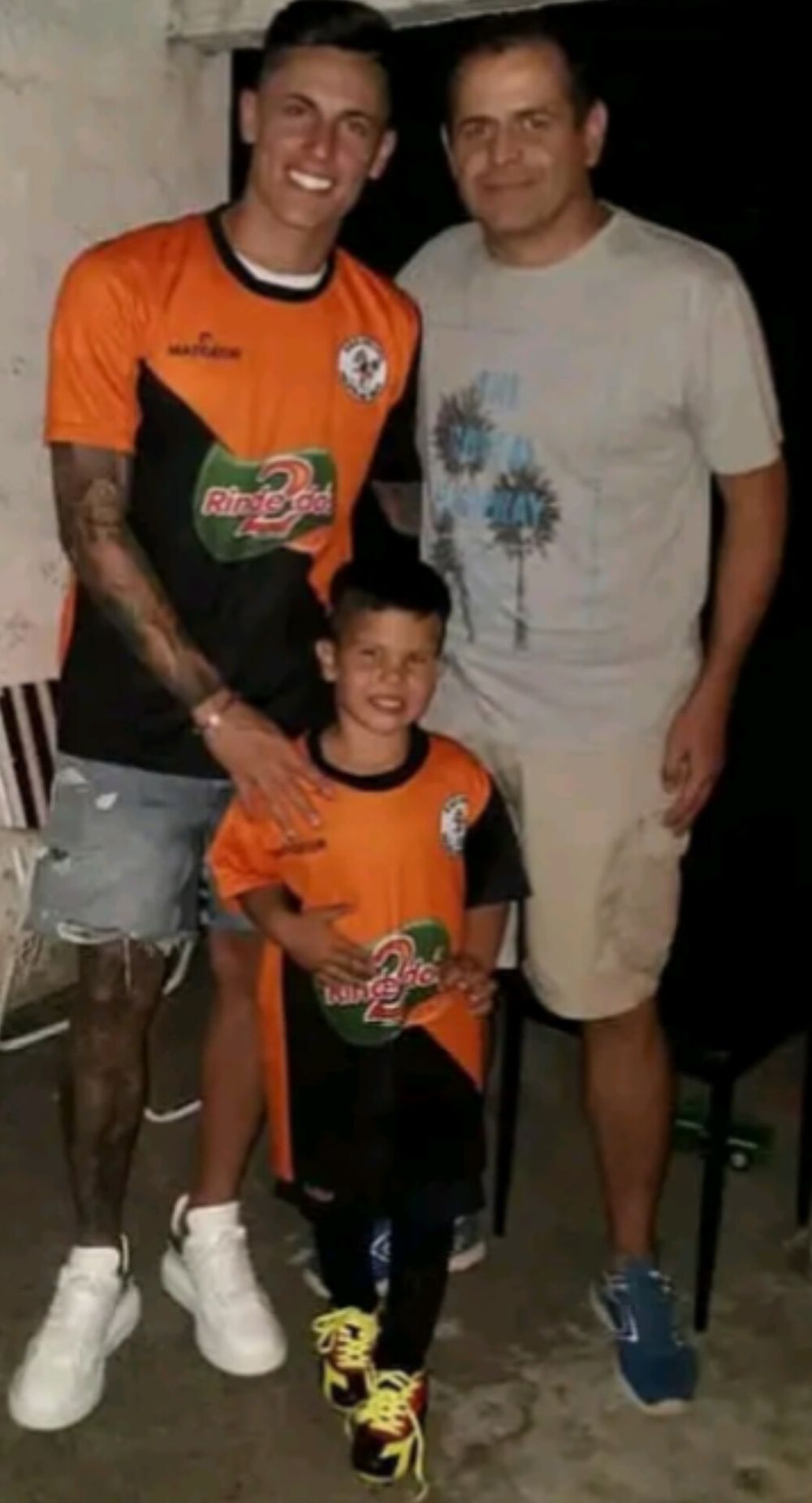 Brian Rodríguez con la camiseta de Pelota de Trapo junto a James, su hermano pequeño, y Tabaré do Prado, su primer entrenador
