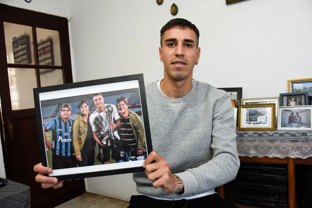 Lucas con un cuadro de sus grandes trofeos: la Supercopa Uruguaya, su madre y sus abuelos