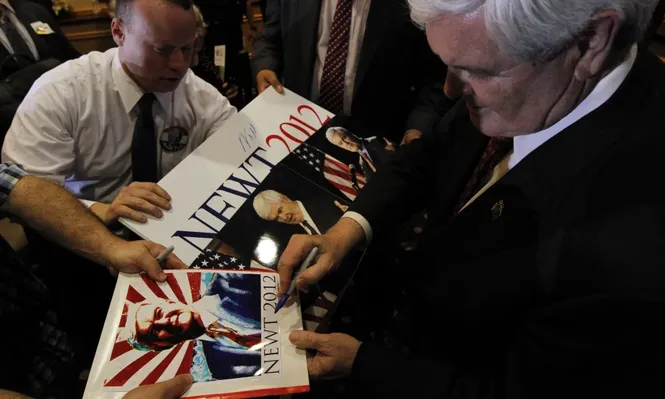 El candidato presidencial republicano Newt Gingrich firmando autógrafos