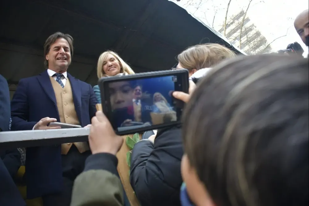 Un niño le saca una foto al presidente y a la vicepresidenta de la República, Luis Lacalle Pou y Beatriz Argimón