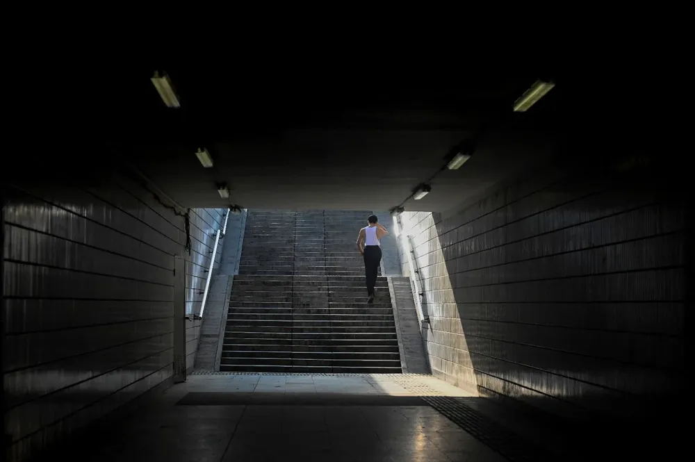 Un hombre sube varios escalones en un subterráneo de Beijing, China