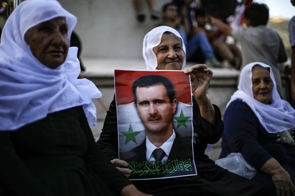 Votantes sirios con carteles del presidente Bashar al Assad