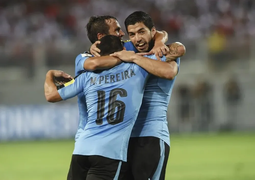 Luis Suárez, Maximiliano Pereira y Álvaro González se abrazan en el festejo de gol