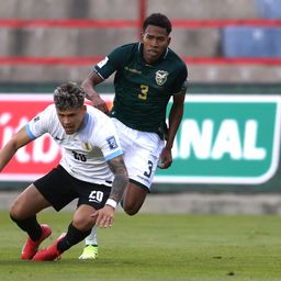 Diego Román de Bolivia disputa un balón con Maximiliano Araújo de Uruguay por Eliminatorias