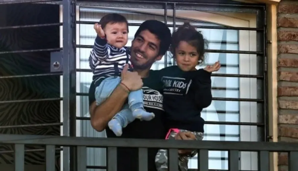 Suárez saludó a la gente desde su casa con sus dos hijos