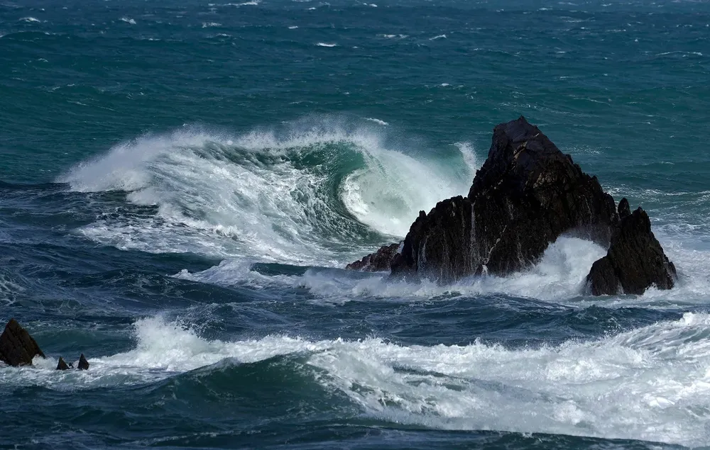 Olas rompiendo en las cercanías del puerto de Cudillero este sábado.