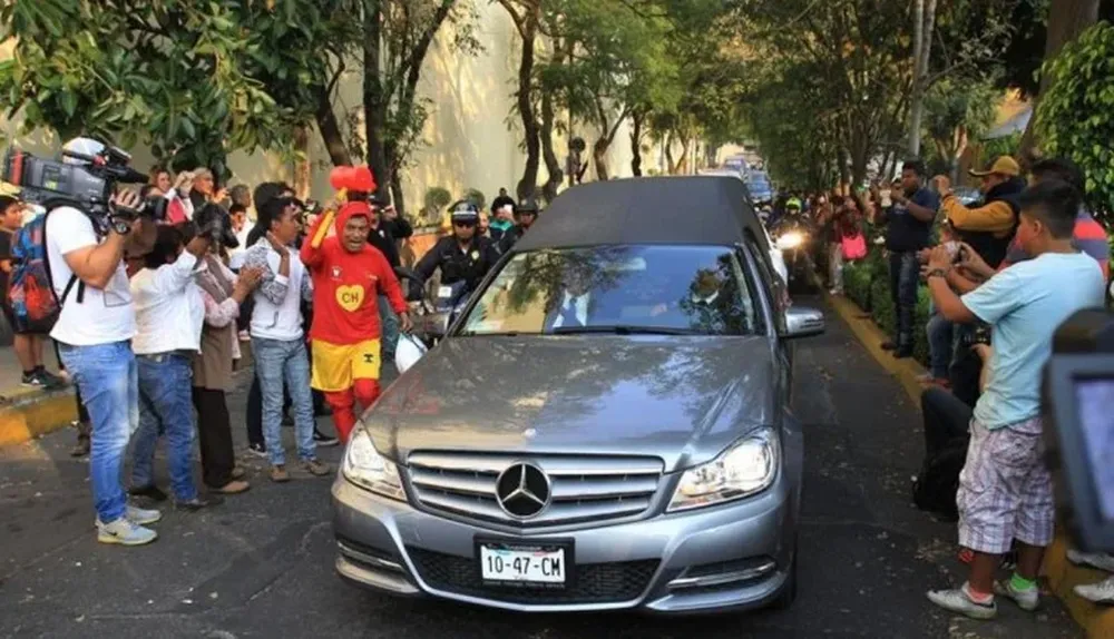 Simpatizantes y medios acompañan la carroza fúnebre que traslada los restos del popular comediante Roberto Gómez Bolaños