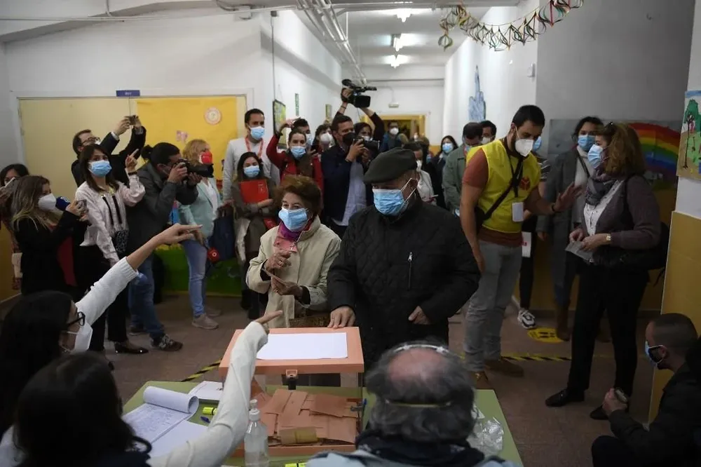 Una pareja de adultos mayores emitiendo sus votos en un colegio electoral en Madrid durante las elecciones regionales del 4 de mayo de 2021.