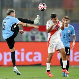 Edison Flores de Perú disputa un balón con Federico Valverde de Uruguay   