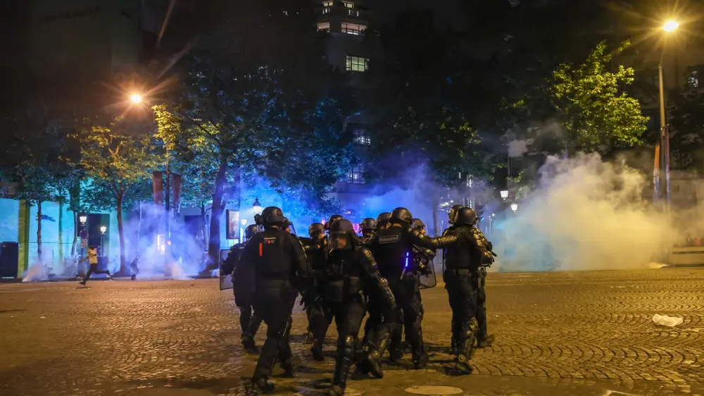Policías en París resistiendo los disturbios tras la consagración del PSG en Champions League.