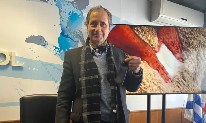 Alberto Bozzo muestra la tela con la que se harán los trajes de la delegación uruguaya que irá a Qatar.