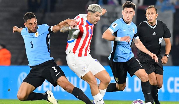 Sebastián Cáceres y Facundo Pellistri de la selección de Uruguay ante Julio César Enciso de Paraguay