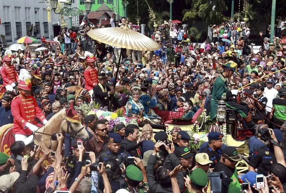 La cuarta hija del sultán de Java Gusti Kanjeng Ratu Hayu y su esposo Haryo Notonegoro saludan a los ciudadanos
