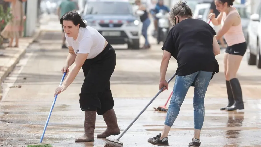Mujeres limpian las calles tras el paso de las tormentas