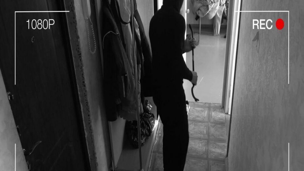 Ladrón cometiendo un robo en una vivienda