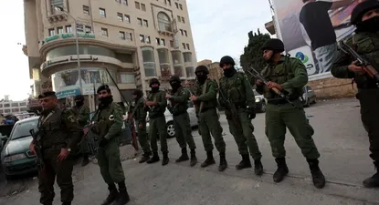 Un grupo de policías palestinos hacen guardia frente a la sede de la televisión árabe Al Jazeera en Ramala, Cisjordania.