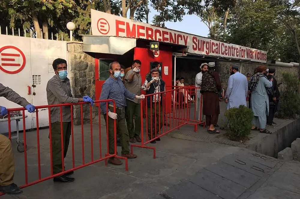 Los miembros del personal médico afgano se encuentran en la entrada de un hospital mientras esperan recibir a las víctimas de una explosión en Kabul.