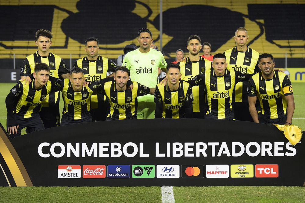 Equipo de Peñarol que enfrentó a San Antonio Bulo Bulo por Copa Libertadores en el Campeón del Siglo, sin hinchas ni banderas por la sanción que Conmebol le aplicó a los aurinegros