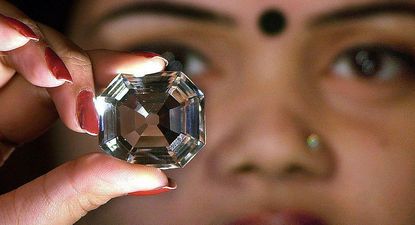 Una mujer sostiene una copia del diamante Koh-i-Noor.