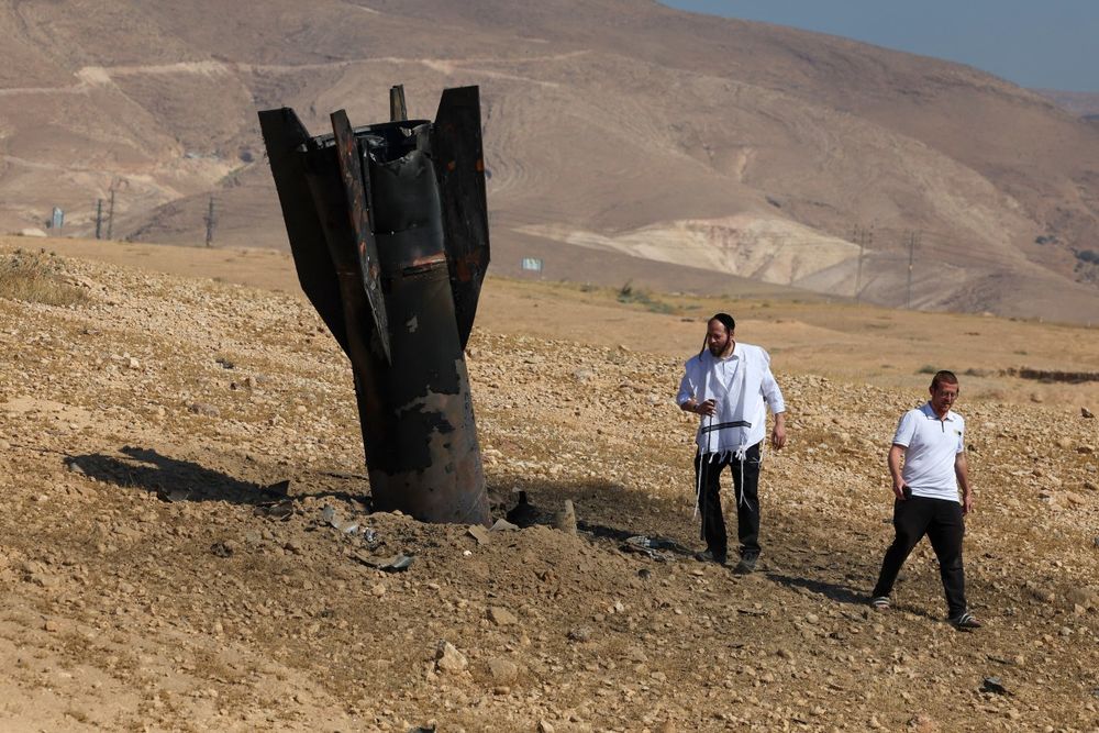 Dos hombres inspeccionan los restos de un misil iraní que cayó cerca de la ciudad cisjordana de Jericó, el lunes 8 de junio de 2026.