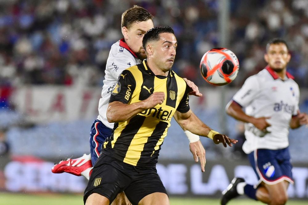 Jaime Báez de Peñarol ante la marca de Sebastián Coates de Nacional