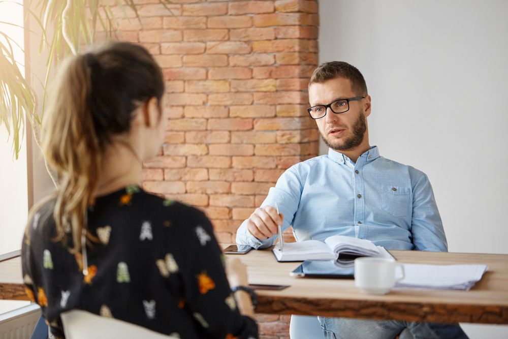 business-concept-dark-haired-anonymous-woman-sitting-table-office-front-serious-mature-human-resources-manager-speaking-about-work-responsibilities-job-interview (1)