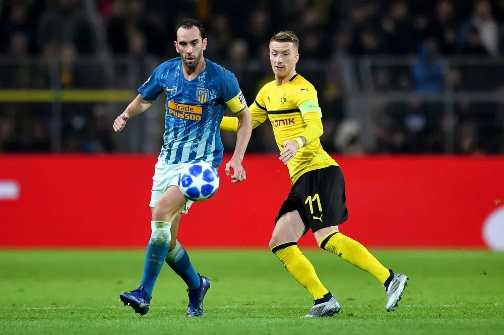 Diego Godín disputa la pelota con Marco Reus en Dortmund