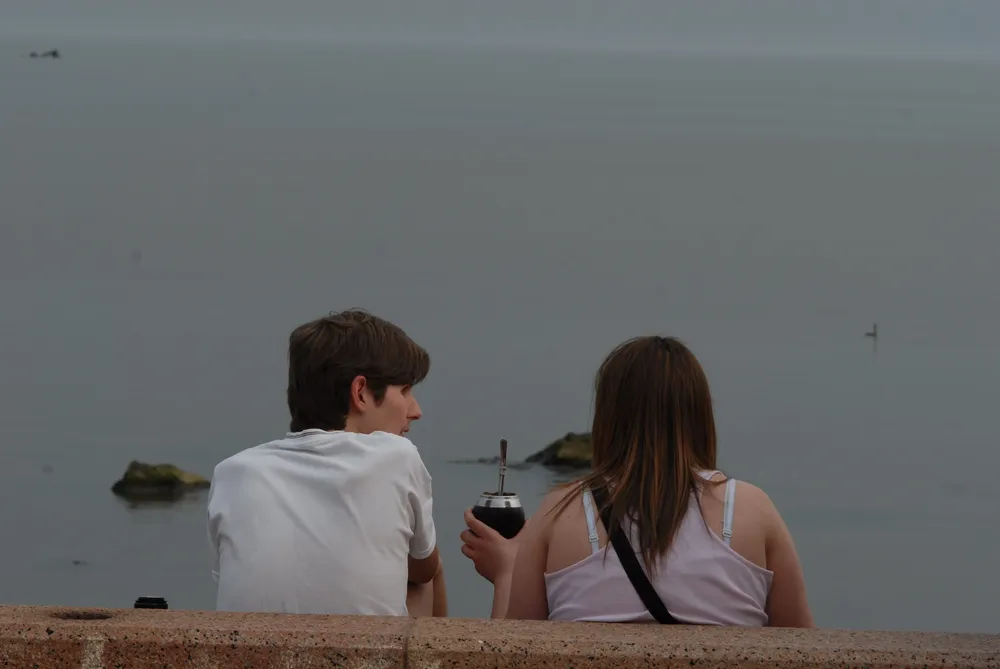 Dos uruguayos toman mate en la rambla de Montevideo