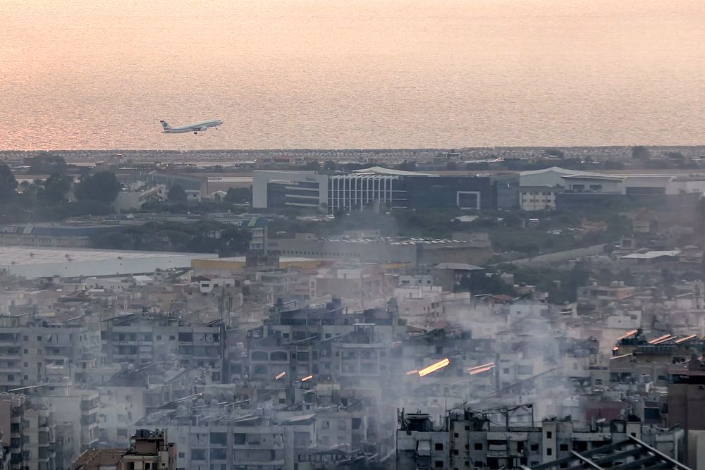 Un avión de Middle East Airlines (MEA), la aerolínea de bandera del Líbano, despega del Aeropuerto Internacional de Beirut el 6 de octubre de 2024 en medio del humo que se eleva desde los sitios cercanos que fueron blanco de ataques aéreos israelíes durante la noche en los suburbios del sur de la capital libanesa.
