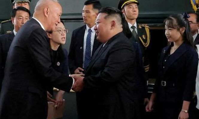 Kim Jong-un saluda al ministro chino Wang Yi, acompañado de su hija, Kim Ju-ae (detrás de él) y otros funcionarios.