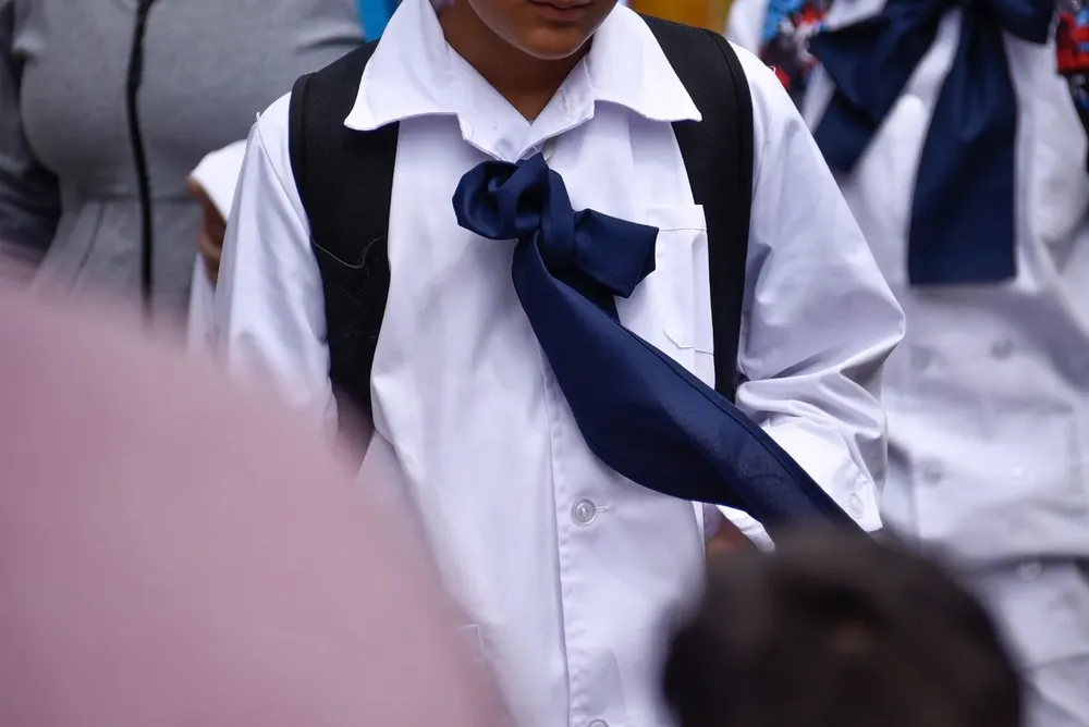 Escolar con túnica y moña