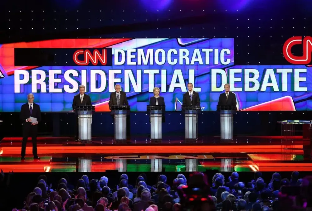 El moderador Anderson Cooper y los precandidatos: Jim Webb, Bernie Sanders, Hillary Rodham Clinton, Martin OMalley y Lincoln Chafee.