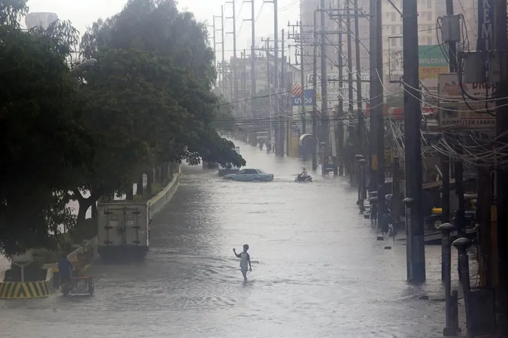 Un niño camina por una calle inundada en Paranque, sur de Manila
