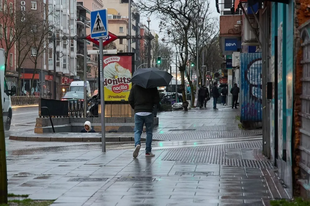 Un hombre se protege de la lluvia con un paraguas durante la borrasca ‘Karlotta’, a 9 de febrero de 2024, en Madrid (España).
