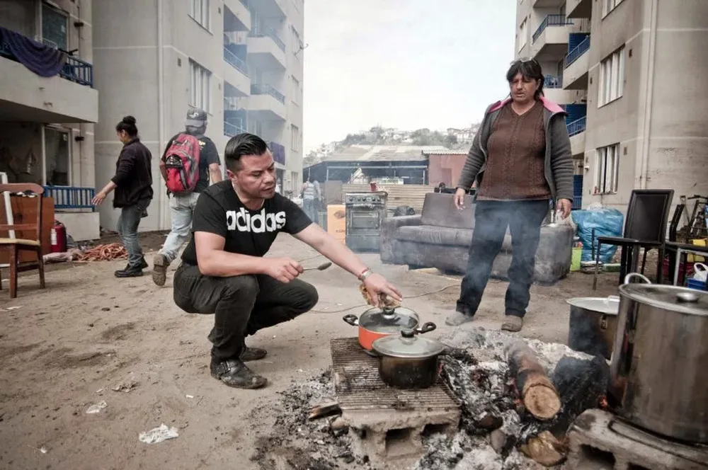 Habitantes de un edificio ubicado en la zona costera preparan los alimentos el sábado tras el tsunami que azotó en la noche del 16 de setiembre