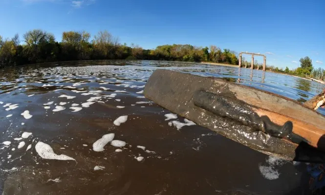Barro y espuma cubren la superficie del río cerca de la represa de Aguas Corrientes