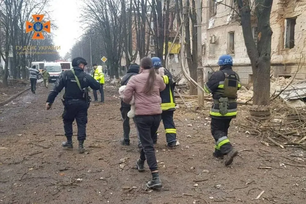 Mujer camina con un niño en una calle bombardeada de la ciudad ucraniana de Kryvyi Rih