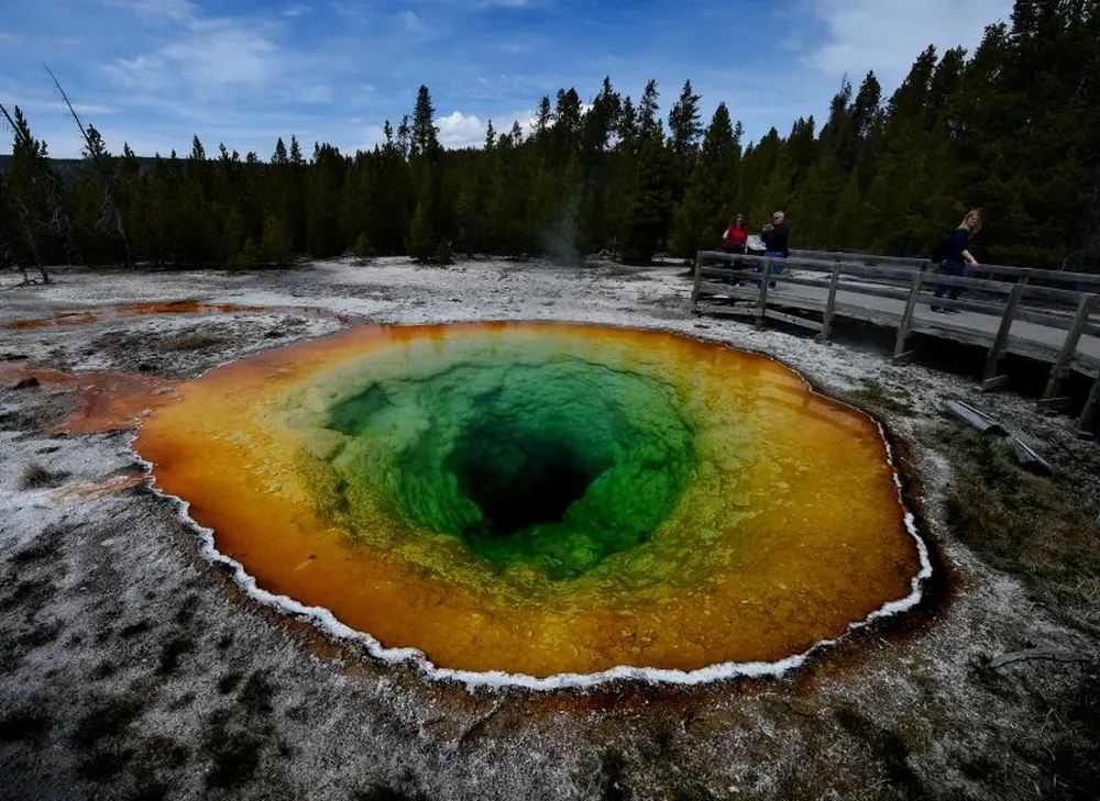 Turistas mirando los geysers en el Parque Nacional Yellowstone en Wyoming, USA.