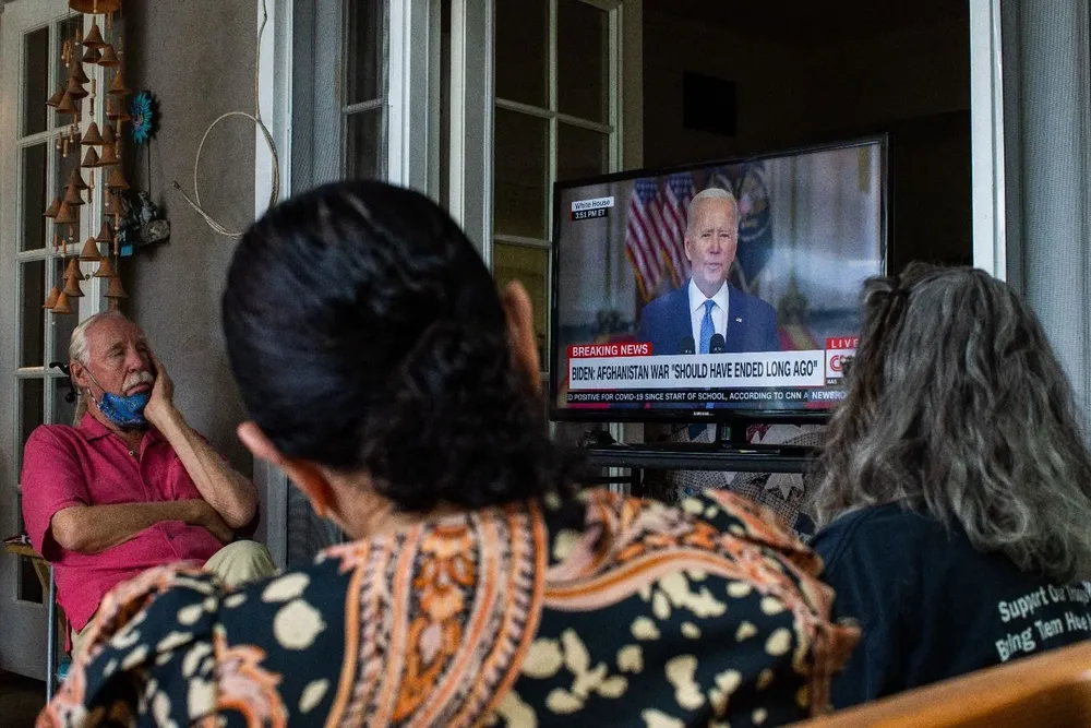 Familias militares, incluido un veterano posterior al 11 de septiembre que sirvió en Afganistán y la madre de un infante y marina que salió del aeropuerto la semana pasada se reúnen para ver el discurso de Biden anunciando que todas las tropas están fuera de servicio