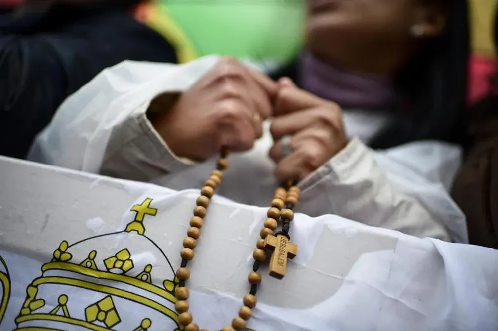 Vaticano- Una monja reza el rosario mientras feligreses celebran la elección del papa Francisco I